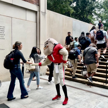 hairy dog greets students