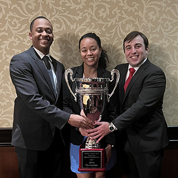 joshua patton, kendra oiglane and hunter payne holding the 2024 Hunter Andrews Kurth national moot court trophy