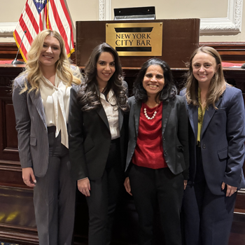 Three competitors stand with Dean Rodrigues at the National Moot Court Competition in Jan. 2025. 