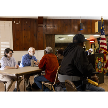 Image of Veterans Legal Clinic Director Alex Scherr talking to clients at an event