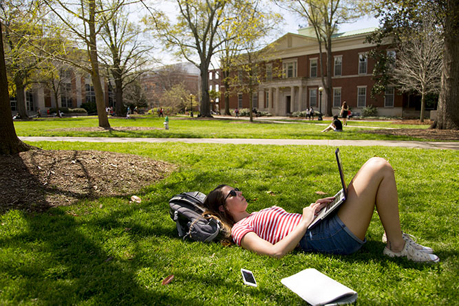 girl studying on lawn